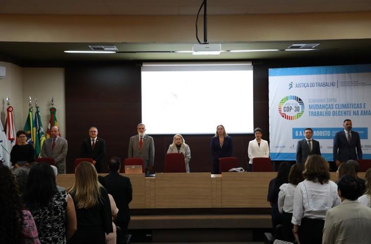 Fotografia em ambiente fechado que reúne dezenas de pessoas entre homens e mulheres.