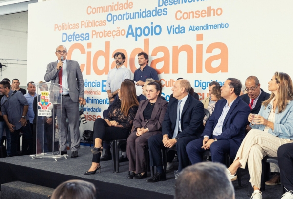 Grupo de autoridades e convidados em um palco durante evento sobre cidadania.