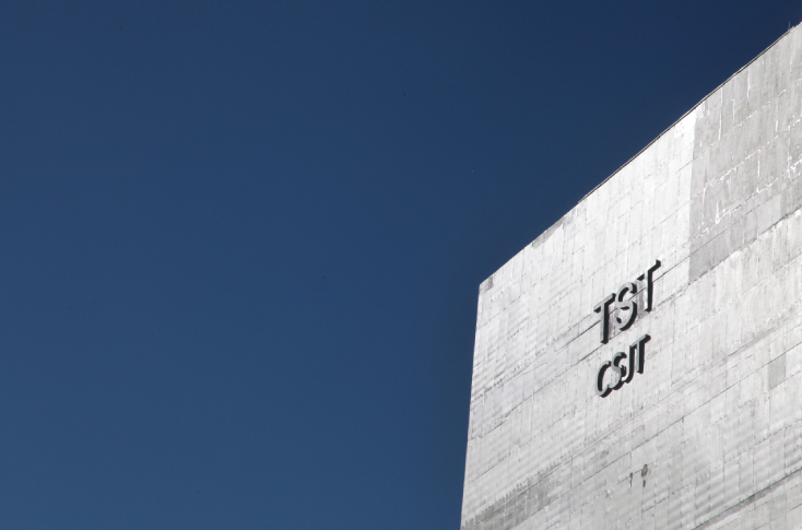 Foto artistica da ponta da fachada do prédio do TST e do CSJT. Ao fundo, o céu azul sem nuvens.