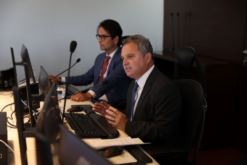 Acordo viabilizado pelo TRT- CSJT 4 Fotografia com dois homens sentados com o computador em frente deles.