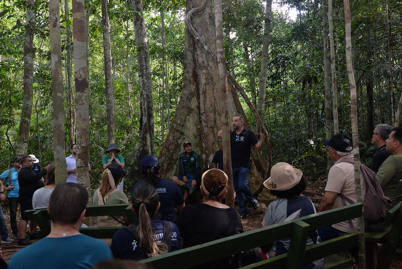 Comunidade Tumbira apresenta à Justiça do Trabalho modelo de vida sustentável na Amazônia - CSJT2 8 Foto dos representantes da Justiça do Trabalho no meio da Floresta em uma apresentação da comunidade.