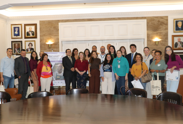 Projeto Reconstrua: ação voltada para empregar pessoas em situação de rua é apresentada no TRT-RJ - CSJT2 12 Grupo de pessoas em pé ao fundo de uma sala.