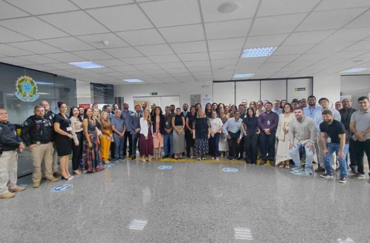 Fotografia de diversas pessoas de pé e sorrindo para a foto.
