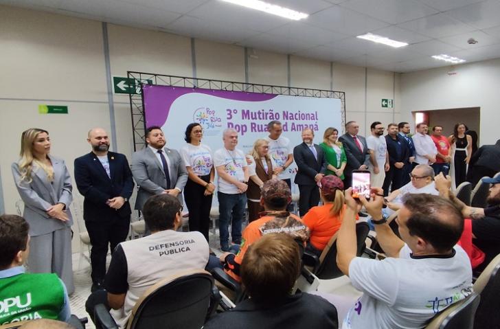 3º Mutirão Nacional Pop Rua Jud amplia acesso a direitos em Macapá - CSJT2 5 Fotografia em ambiente fechado que reúne dezenas de pessoas, entre homens e mulheres.