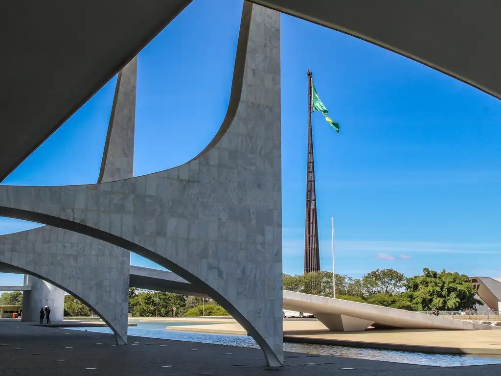 Todas as Notícias 1 Detalhe arquitetônico das colunas do palácio do planalto, com bandeira brasileira ao fundo, na praça dos três poderes
